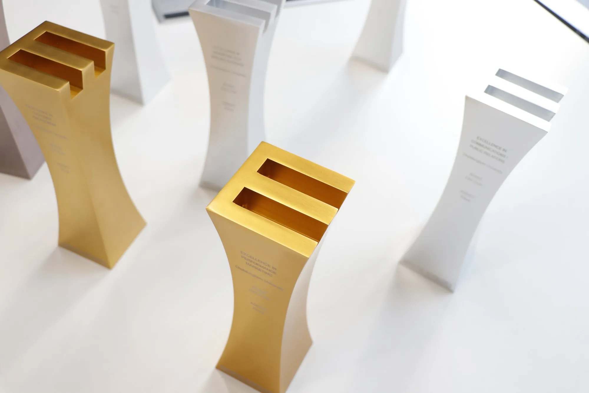Gold and silver Primal industry award trophies on a white background
