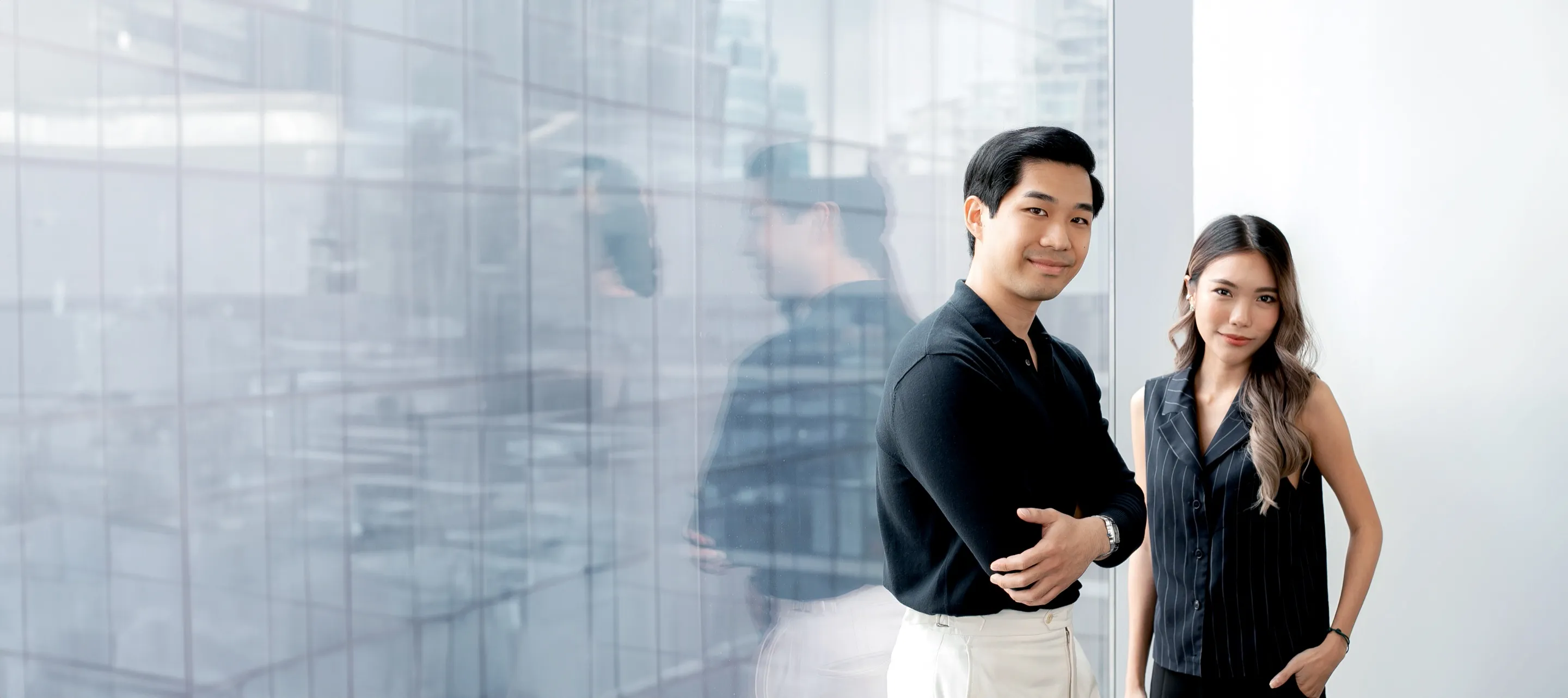 Two Primal strategists standing by a glass office wall